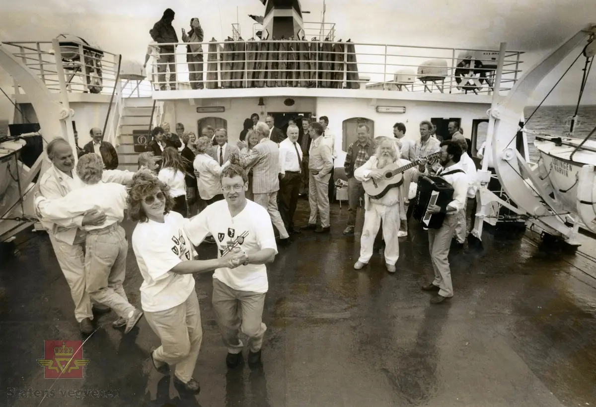 Bildet er tatt ombord i fergen "Lødingen", som åpnet sambandet Bodø - Moskenes 01.07.1990. 

Ombord i MF Lødingen og på veg til åpning av fergeleiene Røst, Værøy, Moskenes og Nappstraumtunnelen 01.07.1990. 
Dans på dekk. Sigbjørn Eriksen, Ragna B. Jørgensen, Jack Berntsen (med gitar), Arne Ivar Løvmo, Harry Jensen,
Evan Furnes, Rolf Bendiksen, Dag J. Fjærvoll, Peter Angelsen.