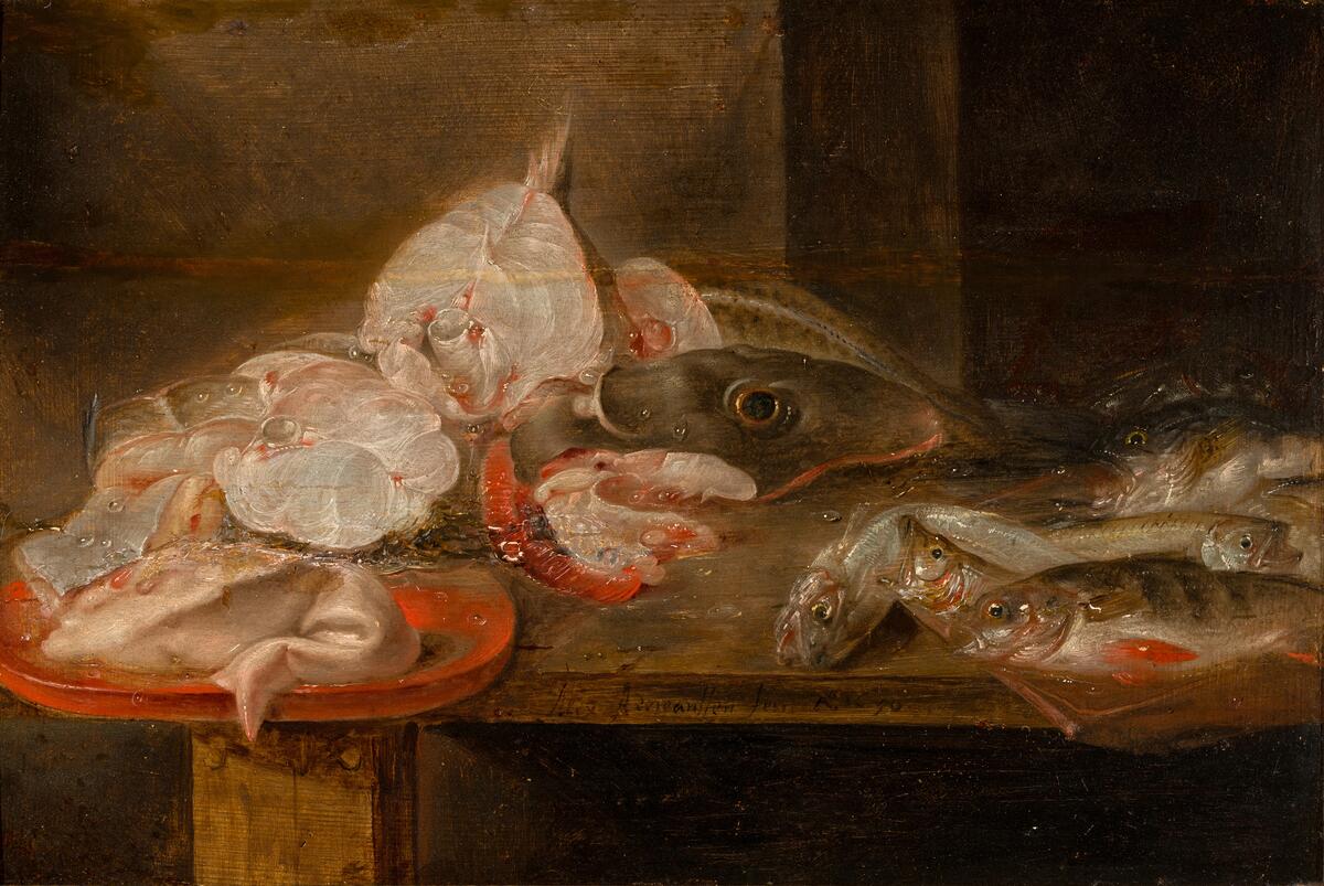 På ett bord ligger olika fisksorter; några fiskar är uppskurna i skivor