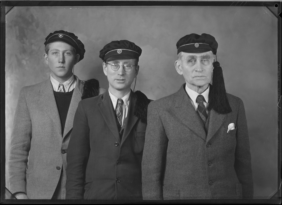 Portrettbilde av tre menn med dress og russelue