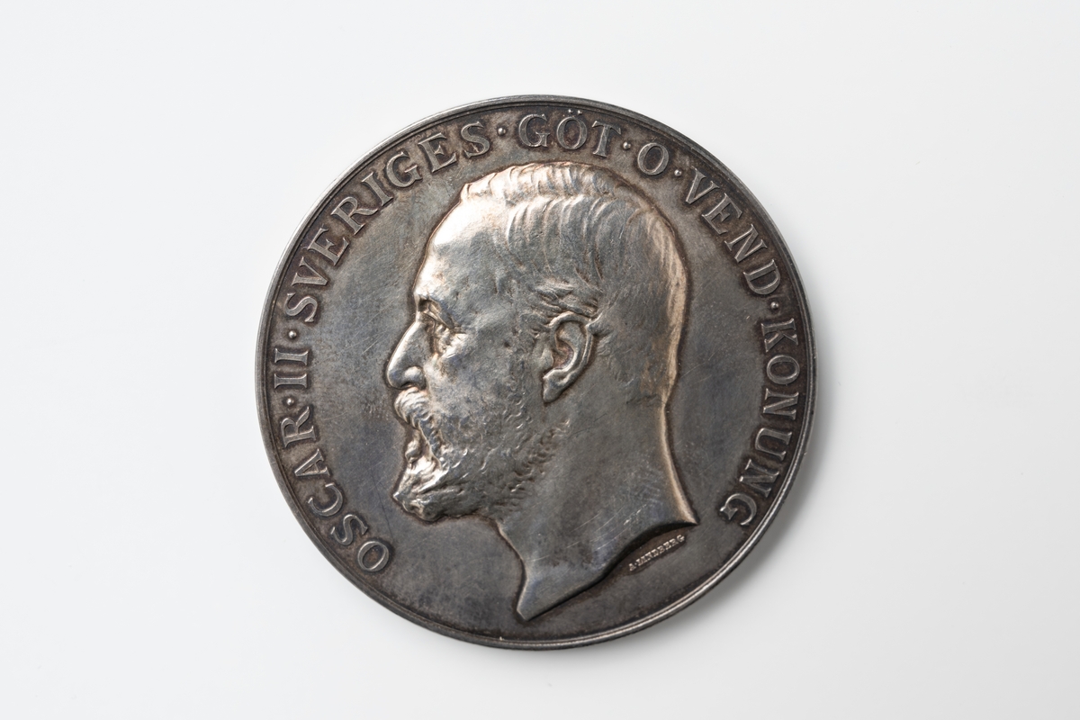 Medalj av silver graverad av Adolf Lindberg. Text runt framsidan: "SVENSKA ALLMÄNNA DJURSKYDDSFÖRENINGEN", och i centrum "Till Folkskollärarinnan Sigrid Bredberg 13/5 1932" samt på vänster sida bild av trädgren med ekblad. Text runt baksidan:" OSCAR II SVERIGES GÖT O VEND KONUNG", och i centrum profilbild av Oscar II.

Till medaljen hör en svart ask klädd invändigt med blått sametstyg i botten och gult sidentyg på insidan av locket.