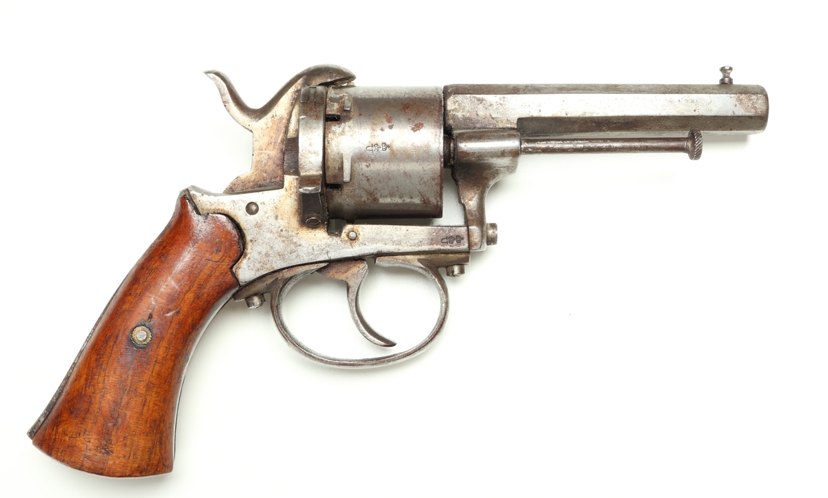 Revolver av så kallad Lefaucheuxtyp i stål med kolvplattor i trä, och plats för sex stiftantändningspatroner i trumman. Laddning sker genom att laddluckan på höger sida om trumman fälls upp, och därefter patroner förs in i patronläget. Framtill på höger sida finns en utstötare för de avlossade patronhylsorna. På pipan vid mynningen sitter ett stolpkorn. Revolvern är märkt med två kronor och ett "U" på trumman och höger sida ovanför varbygeln.
Inskrivet i huvudkatalogen 1974.