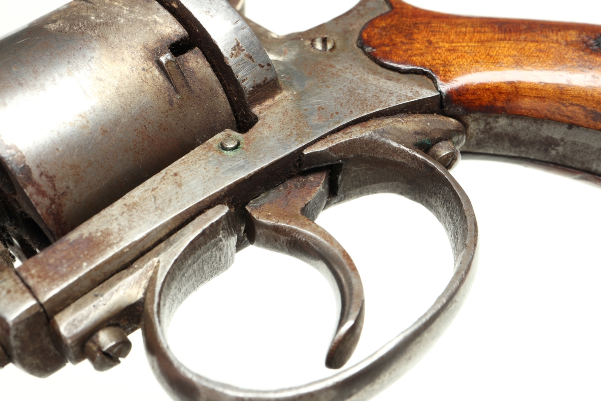 Revolver av så kallad Lefaucheuxtyp i stål med kolvplattor i trä, och plats för sex stiftantändningspatroner i trumman. Laddning sker genom att laddluckan på höger sida om trumman fälls upp, och därefter patroner förs in i patronläget. Framtill på höger sida finns en utstötare för de avlossade patronhylsorna. På pipan vid mynningen sitter ett stolpkorn. Revolvern är märkt med två kronor och ett "U" på trumman och höger sida ovanför varbygeln.
Inskrivet i huvudkatalogen 1974.