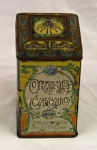 Boks. Rektangulær. Kvadratisk bunn/topp. Metall. Påhengslet lokk. Lokket er avrundet mot topp med 4-kant i relieff. Illustrasjoner av dronning, landskap og logo.  Noe rusten. Inneholder knapper.