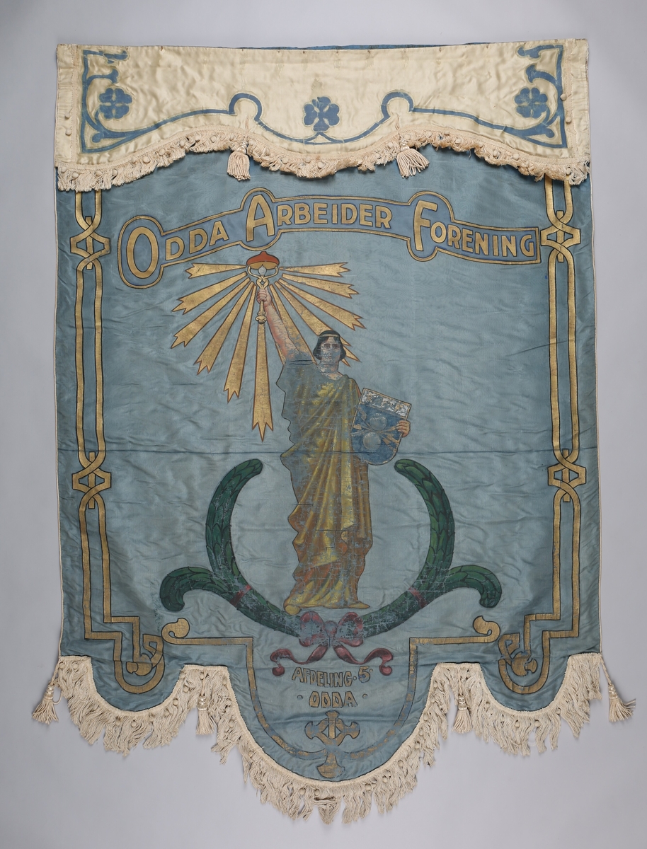Motiv på framsida: Gudinne som held ein elektrisk lampe (jugendstil). Motivetog dekor  har trekk av jugendstil; svungne liner. Motiv på framsida: fridomsgudinna er plassert i sigerskransen (lauvbærkransen) og ho held eit skjold med Elektrikerforbundet sitt emblem i venstre hand. I staden for ein fakkel som symboliserer opplysning, held ho ein lysande elektrisk lampe i høgre. 