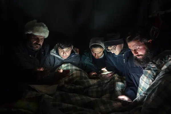 Bilde av en gruppe personer i Moria flyktningeleir. Bildet er tatt på kvelden.