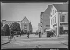 St Larsgatan i Linköping. Korsningen med Kungsttan. Till vänster Skrädderi för både miliär- och civila kläder. I mitten av bild Frimurarhotellet. I mitten ser man även en cyklande polis. Cykel. Cigarraffär. Speceriaffär. Folkvimmel. Centrala Linköping. Gatuvy. 

Bilder från gatuhörn i staden Linköping åren 1909 till 1913. Bilderna är tagna i centrala Linköping i ett projekt att dokumentera Linköping för Linköpings stad.