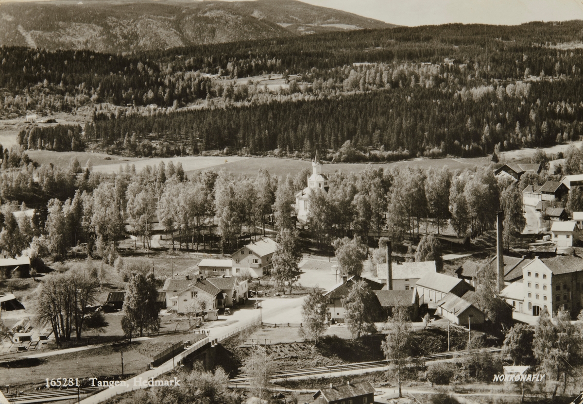Postkort, Stange, flyfoto, Tangen sentrum, Skaun Tangen landhandleri og Tangen samvirkelag til venstre, Tangen kirke, over gata til høyre Tangen meieri, Tangen brenneri, riksveg 50 med bru over jernbanesporet,