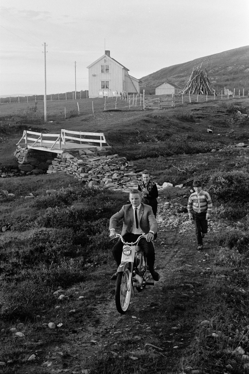 Pent kledde ungdommer med moped i kystlandskap.