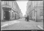 Klostergatan i hörnet mot Borgmästaregatan. Man ser en häst och vagn på kullerstensgatan.
Till vänster i bild ser man Oskar Andersson Specerier och delikatesser. 
Bilder från gatuhörn i staden Linköping åren 1909 till 1913. Bilderna är tagna i centrala Linköping i ett projekt att dokumentera Linköping för Linköpings stad.