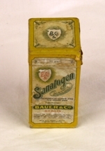 Boks. Papp. Rektangulær med kvadratisk lokk og bunn. Lokket trees på. Pålimt papir rundt boksen med skrift og illustrasjoner. Illustrasjon av 2 småpiker på en side. Gutt på motsatt side.