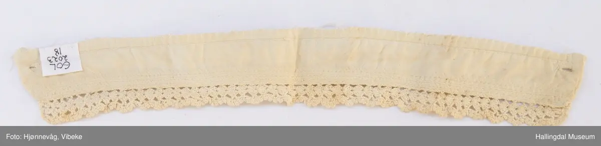 Hvit halslinning til bunadskjorte. Bomullslerret med heklet kant øverst. 3 rader med broderi under kanten.