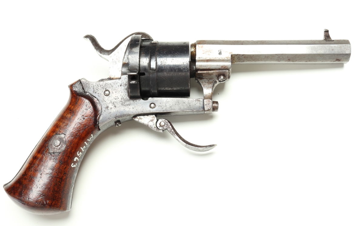 Revolver av så kallad Lefaucheuxtyp i stål med kolvplattor i trä, och plats för sex stiftantändningspatroner i trumman. Pipa i stål, kolv av brunbetsat trä, utan varbygel, samt med fällbar avtryckare. Trumman och sidoblecken blånerade. På pipan, vid mynningen, sitter ett stolpkorn i mässing. Laddning sker genom att laddluckan på höger sida om trumman fälls upp, och därefter patroner förs in i kamrarna. Framtill, på höger sida, finns en utstötare för de avlossade patronhylsorna. Revolvern är märkt med en krona och ett "U" på trumman och höger sida under utstötarstångens fäste, samt även "LIG" inom oval på trumman.
Inskrivet i huvudkatalogen 1947.