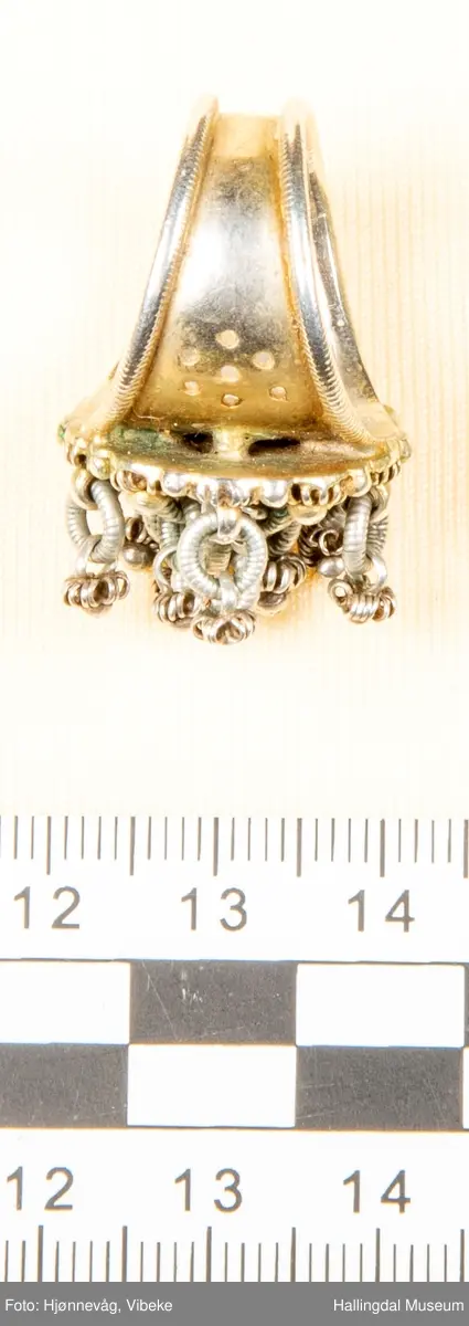 Fingerring med 10 små ringer som det er festet små ringer og "kuler" i.  2 kuler mangler. Filigransarbeid.