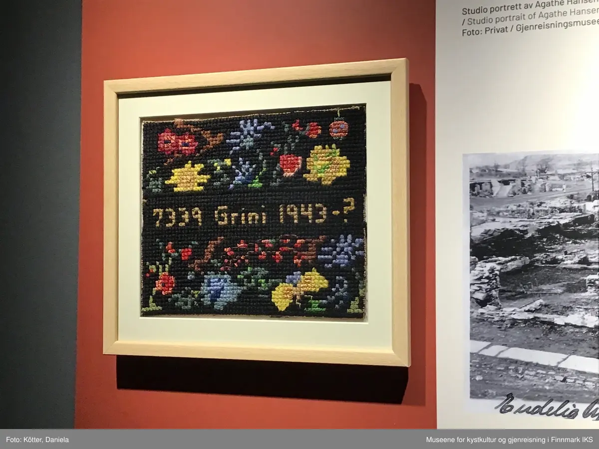 Korsstingbroderiet er utført med bomullsgarn i ulike farger på et  vevd grunnstoff som sannsynlig er av papirmateriale. Motivet viser blåe, gule og røde blomster på svart grunn. I midten ble det brodert inn fangenumre som Agathe Elfrida Hansen fikk tildelt i Grini fangeleir.