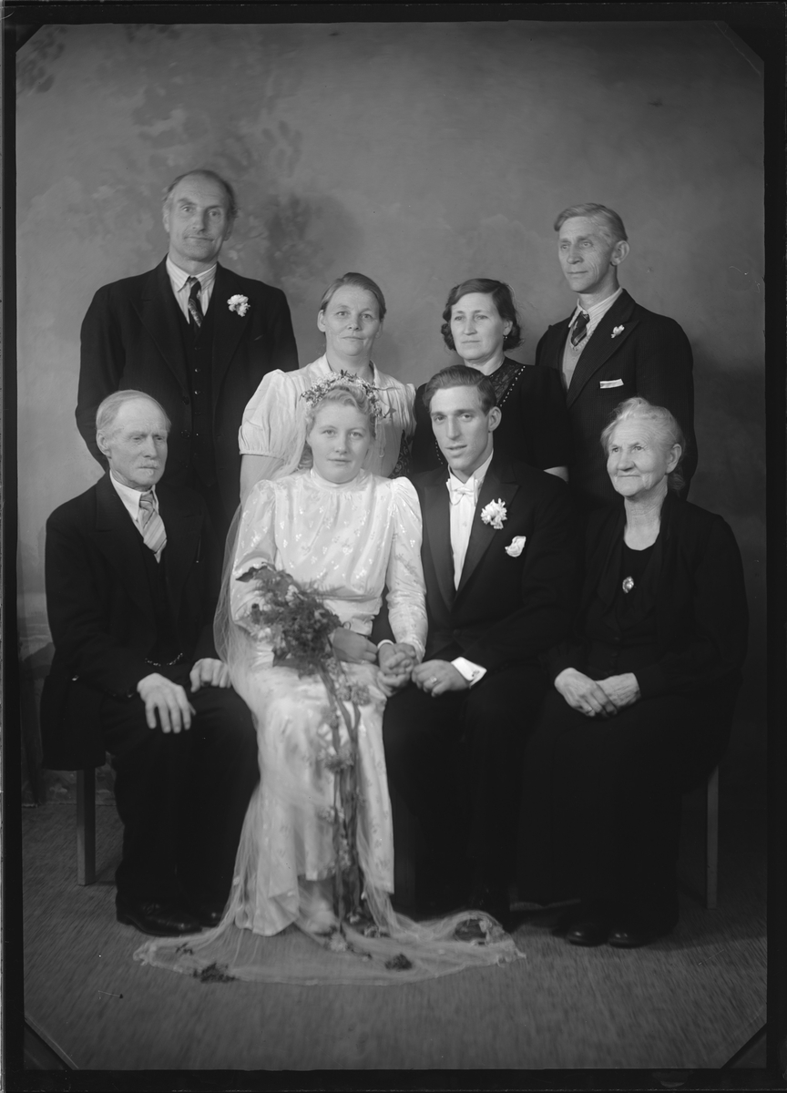 Portrett av brudepar med venner/familie