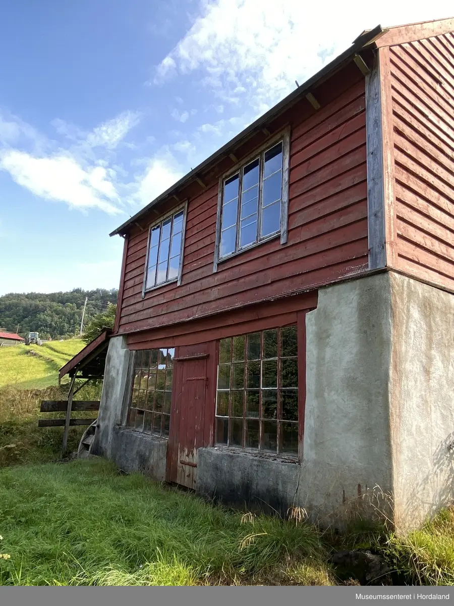 Raudmalt smie med tak i bølgeblekk. Opphaveleg drevet med vasskraft frå Loneelva. 