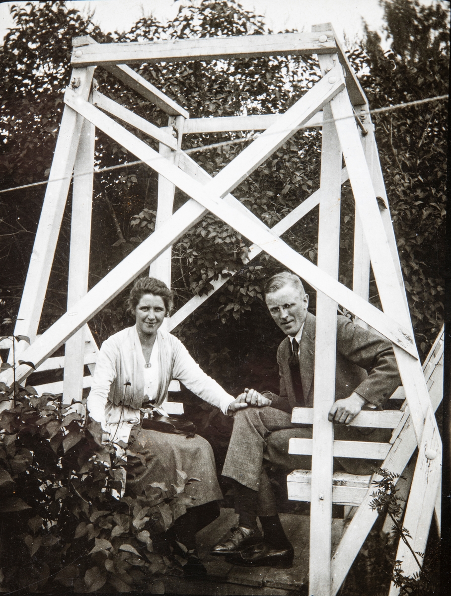 Kjøpmann Magnus Godager (f:1894 - d: 1962) i Stange, sittende i en hagegynge sammen med sin kone Agnes Lovise Godager, født Agnes Lovise Melby (f: 1893- d: 1982). 
Magnus og Agnes giftet seg i 1920.