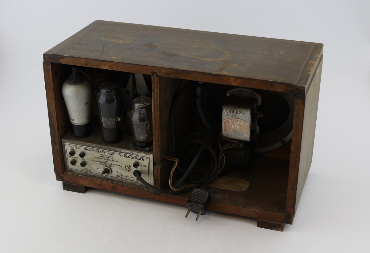 Brun rektangulær radio av tre med høyttaler, display og vridere for valg av stasjon.