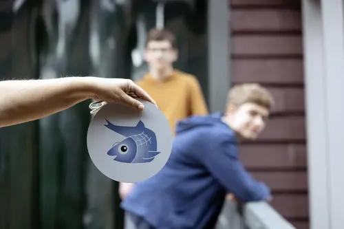 Bildet viser en hånd som holderskilt med Silja Sild maskot på