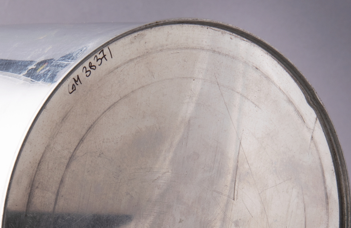 Burk i aluminium, rund med lock. På locket klistrad lapp: Provburk å ALUMINIUM.