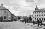 I höjd med Gamla torget och med kameran riktad mot Dalsgatan togs detta motiv en sommarhalvårsdag i början av 1900-talet. Resultatet bearbetades för att pryda brevkort och just detta skickades 1906 till herr Sven Örtegren i Forshaga.