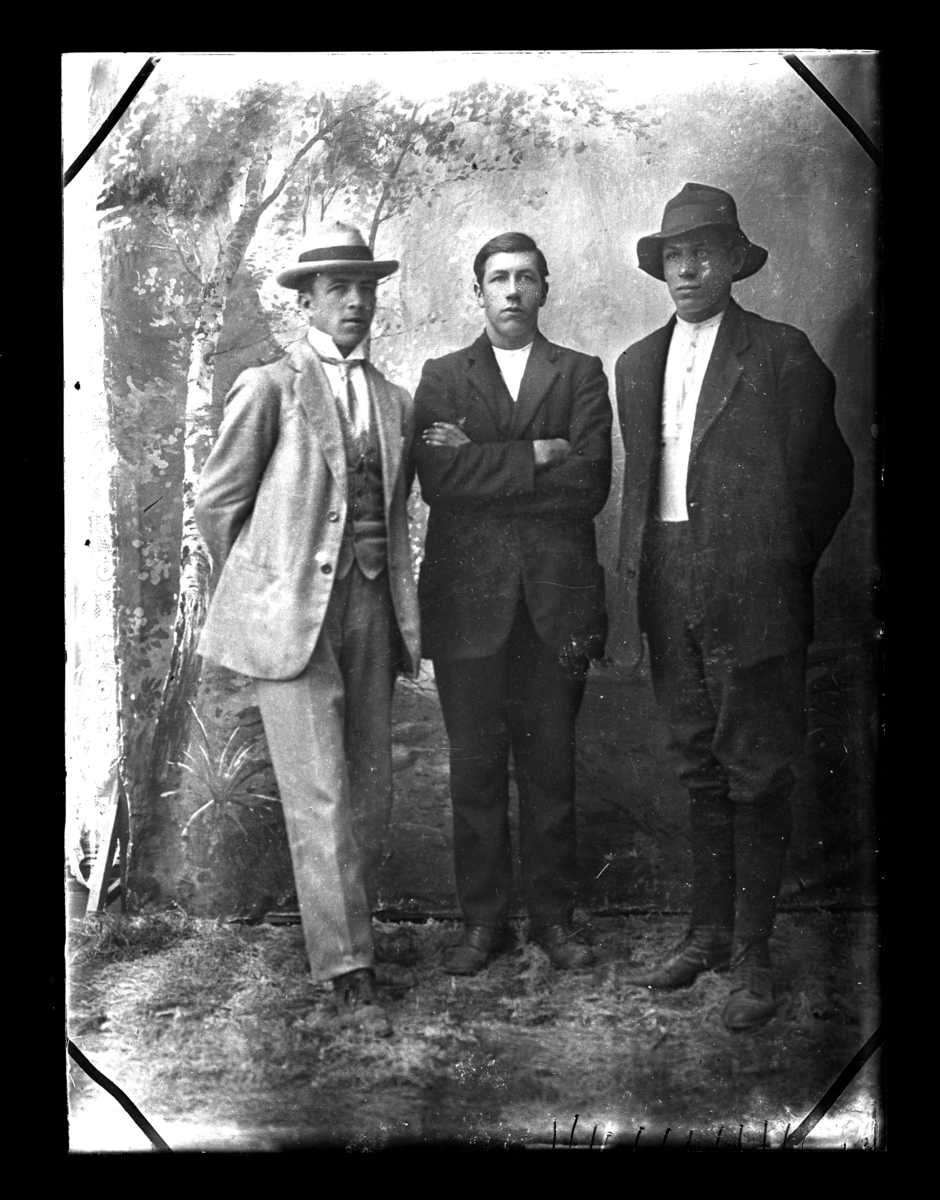 Atelierfoto. Helfigurer. Tre menn.
Det er skrevet noe på negativet:  "Helmer Danielsen Rena"
Overstreket: "Magnus Karlstad......" 
 ( se bilder GM_MG.00273_1 og GM_MG.00273_2).