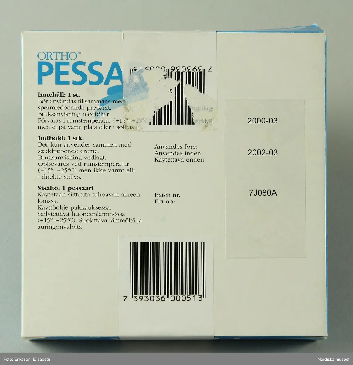 a) Pessarkopp i gulvitt gummi med b) förvarsingsask för pessar i blå plast, c) blå förpackning i kartong samt d) bruksanvisning.