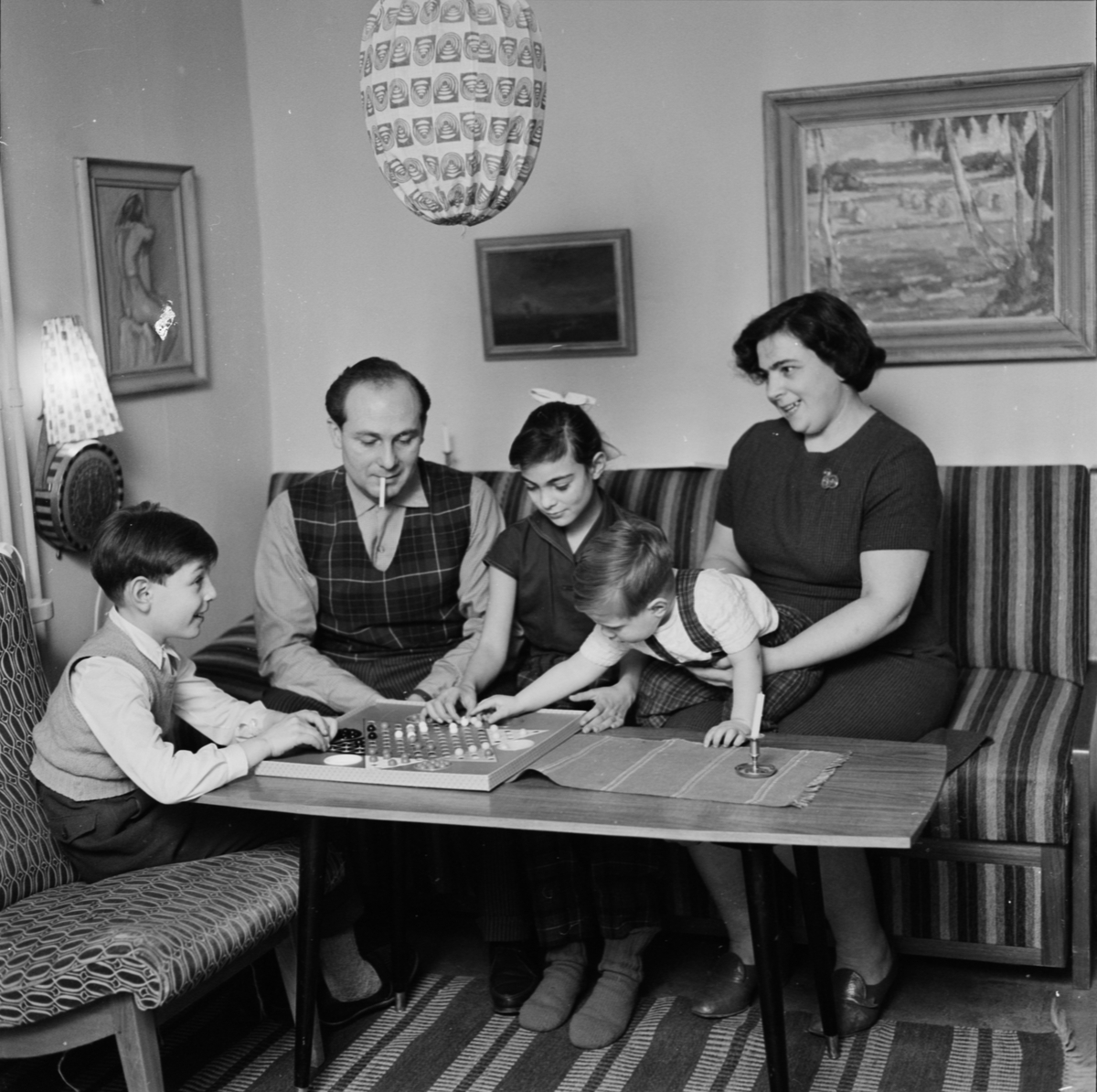 Familjen Klein spelar kinaschack hemma vid soffbordet.