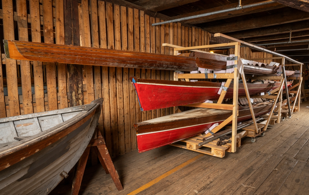 Utriggad 4:a, KLINKAN. Klinkbyggd i mahogny med dukat däck. Längd 12,9 m. Bredd 0,55 m. Vikt 100 kg. Utrustad med 4 fotplattor, 1 roder, 4 åror och 4 utriggare.