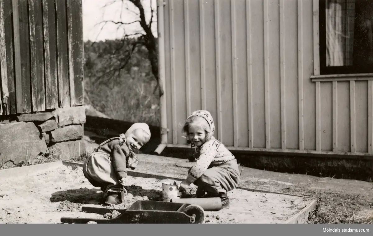 Eva Pettersson (gift Kempe) och kusinen Stina Krantz leker i sandlådan, Torrekulla gård 1947.