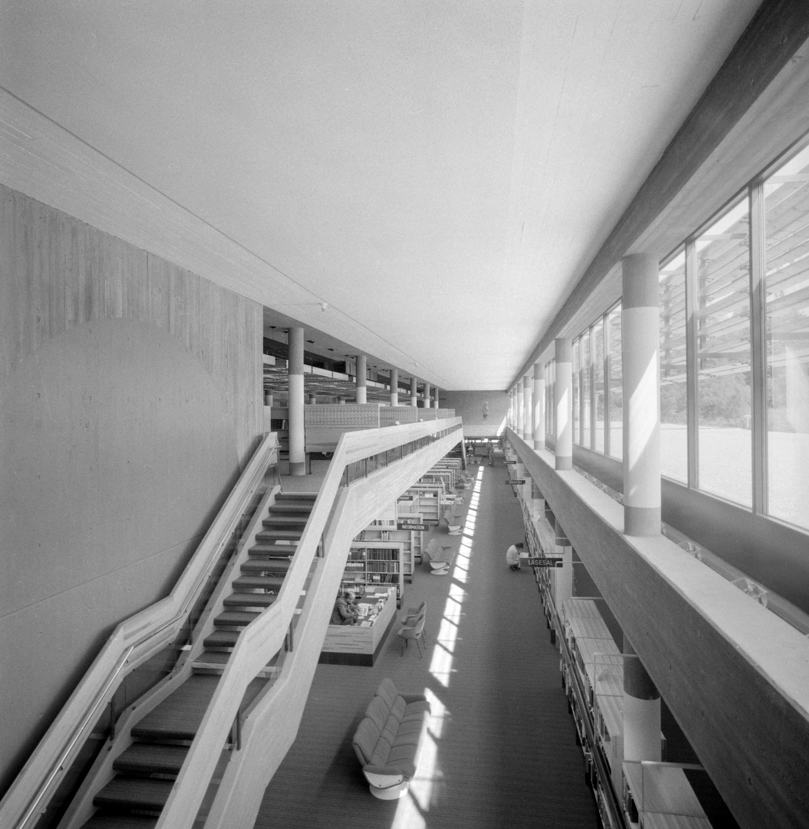 Det nya stifts- och landsbiblioteket i Linköping invigdes officiellt den 6 juni 1974 men hade då redan varit öppet för allmänheten en tid. Stort, luftigt och med all service en besökare kunde tänkas önska. Vid disken sitter bibliotekarie Gunilla Andersson och i den i studier försjunkne mannen ser vi bibliotekets mångårige medarbetare Allan Ranius.