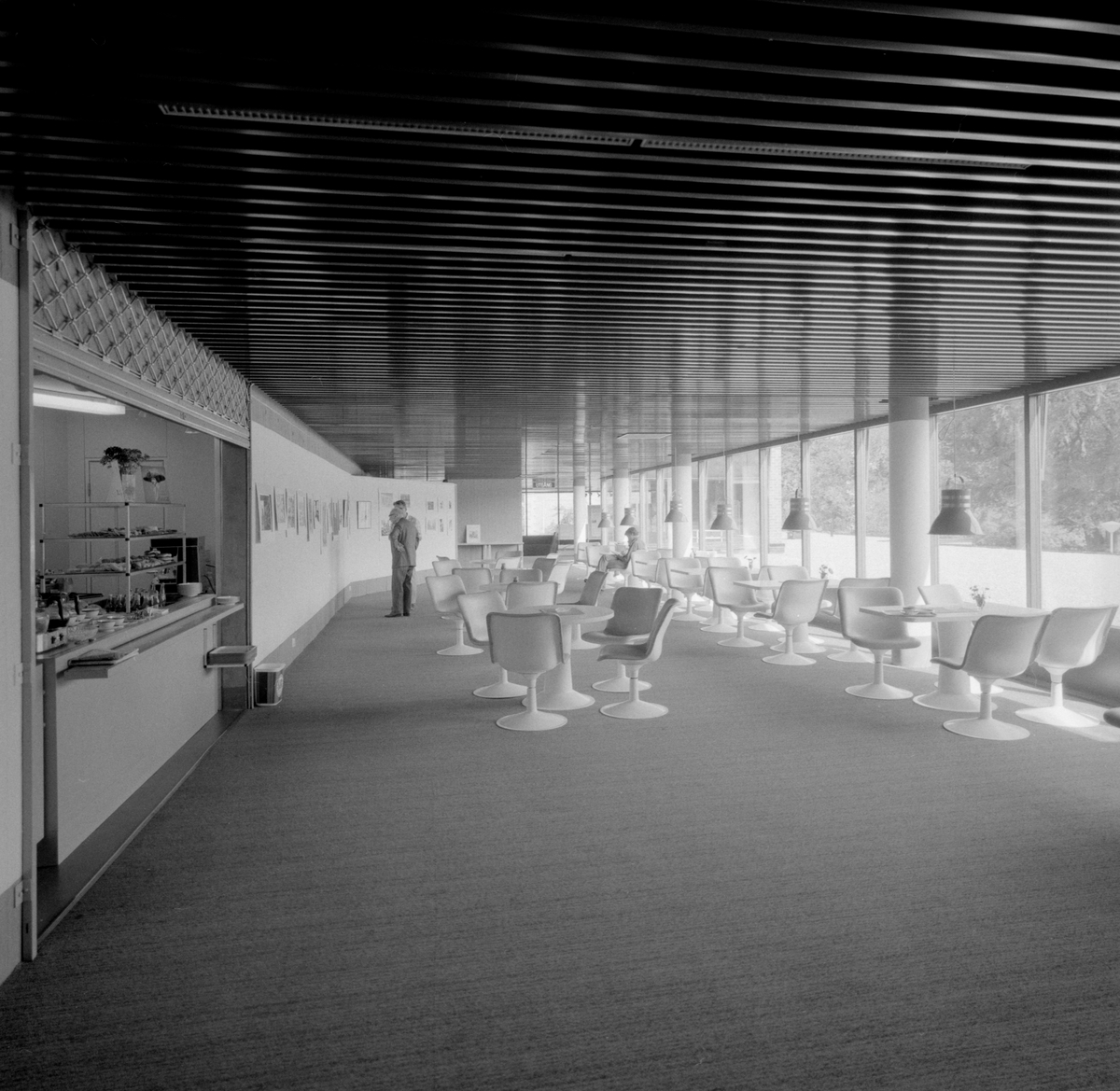 Det nya stifts- och landsbiblioteket i Linköping invigdes officiellt den 6 juni 1974 men hade då redan varit öppet för allmänheten en tid. Stort, luftigt och med all service en besökare kunde tänkas önska. Vid disken sitter bibliotekarie Gunilla Andersson och i den i studier försjunkne mannen ser vi bibliotekets mångårige medarbetare Allan Ranius.