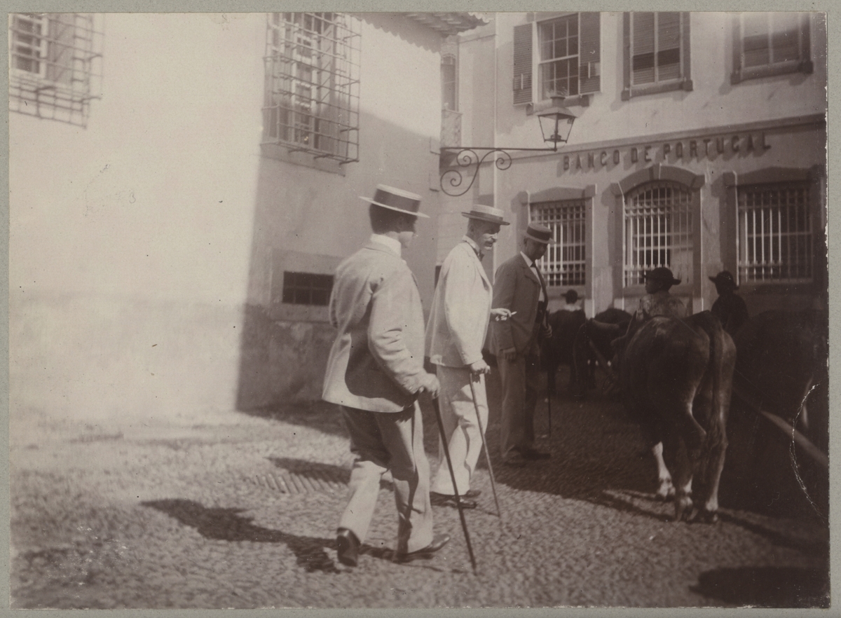 Tre besättningsmedlemmar från Balder i civila finkläder med käppar promenerar på en gata på Madeira.