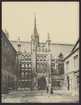 Bilden visar The Guildhall i London. Platsen framför byggnaden är glest befolkat av några passanter och duvor.