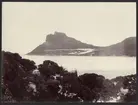 Bilden visar en havsviken Hout Bay i Sydafrika som är inramad av höga bergsklippor.