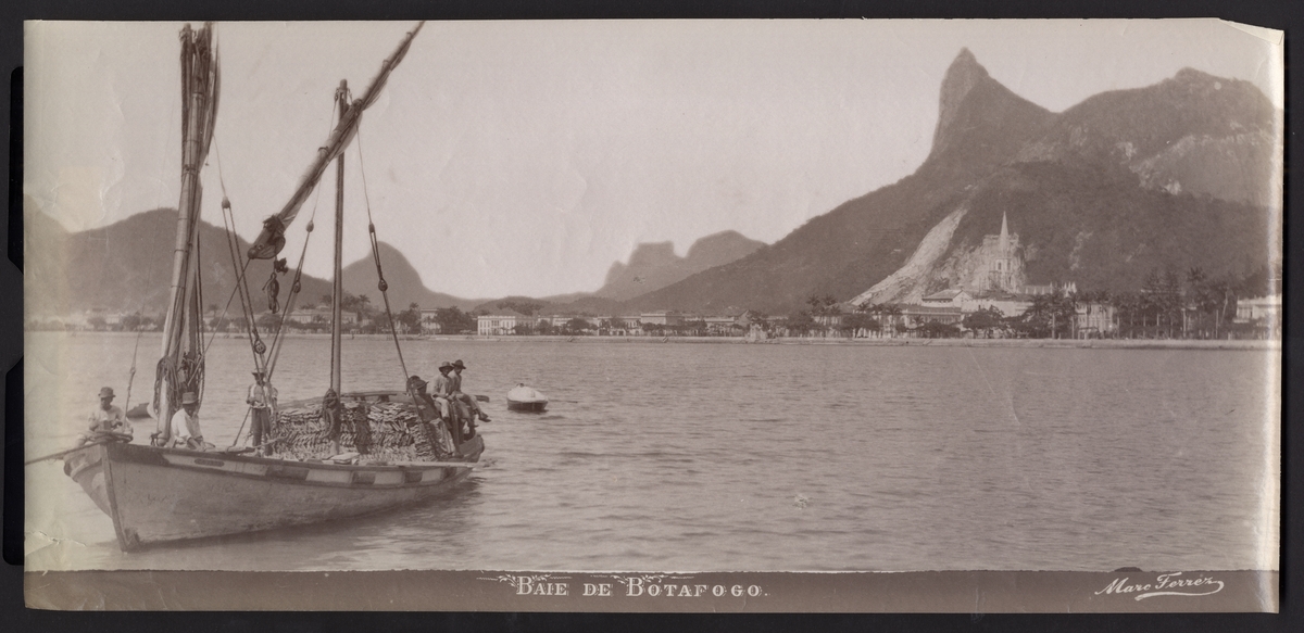 Bilden föreställer en vy över viken Baie de Botafogo i Rio de Janeiro från havet. På vänster sidan syns en segelbåt som transporterar en lass tegelpannor.