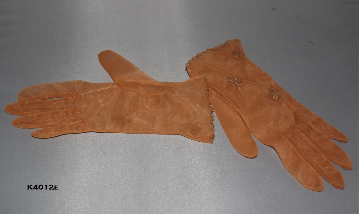 a) Sorte hansker. Nylon. Rynker ved håndledd.
b) Blå og grå hansker i blonde og nylon.
c) Off hwite hansker i nylon. Blomster brodert på håndbakk. 
d) Grå hansker i nylon med broderte blomster bak.
e) Seneppsgule hansker i nylon. Broderte blomster.Ettikett "8" påmontert.