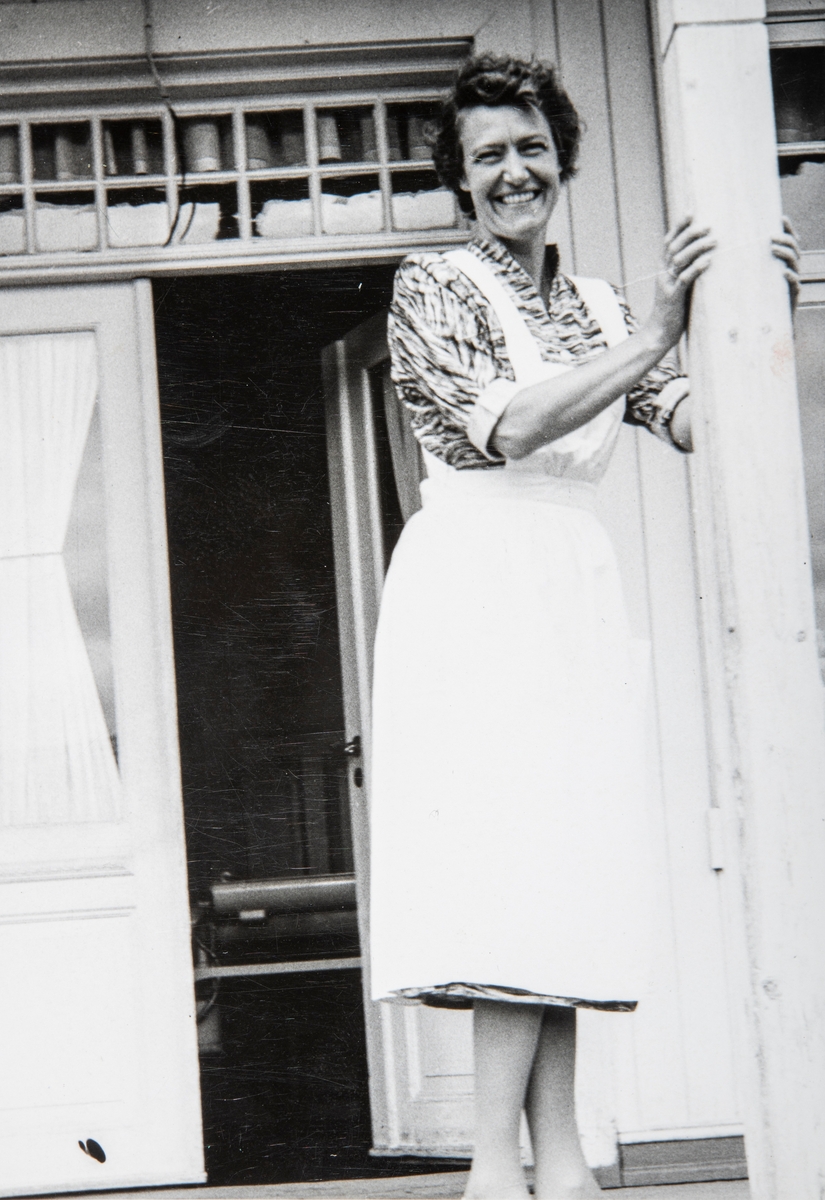 Grylling barnepensjonat og sommerleir, Løten. Inger Karterud f. Slagsvold (1911–1959) stående i inngangspartiet på Garden Grylling vestre, Nordbygda, Løten.  
1950-tallet. Hun drev Grylling barnepensjonat og sommerleir sammen med mannen Jon Karterud.