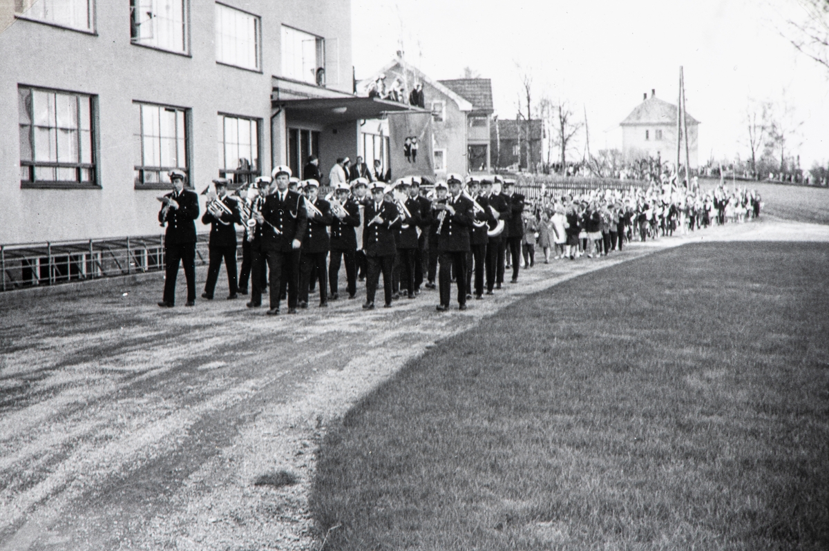 17. mai utenfor Østlandske Vanførehjem i Ottestad. Musikkorps med skoletoget etter seg.