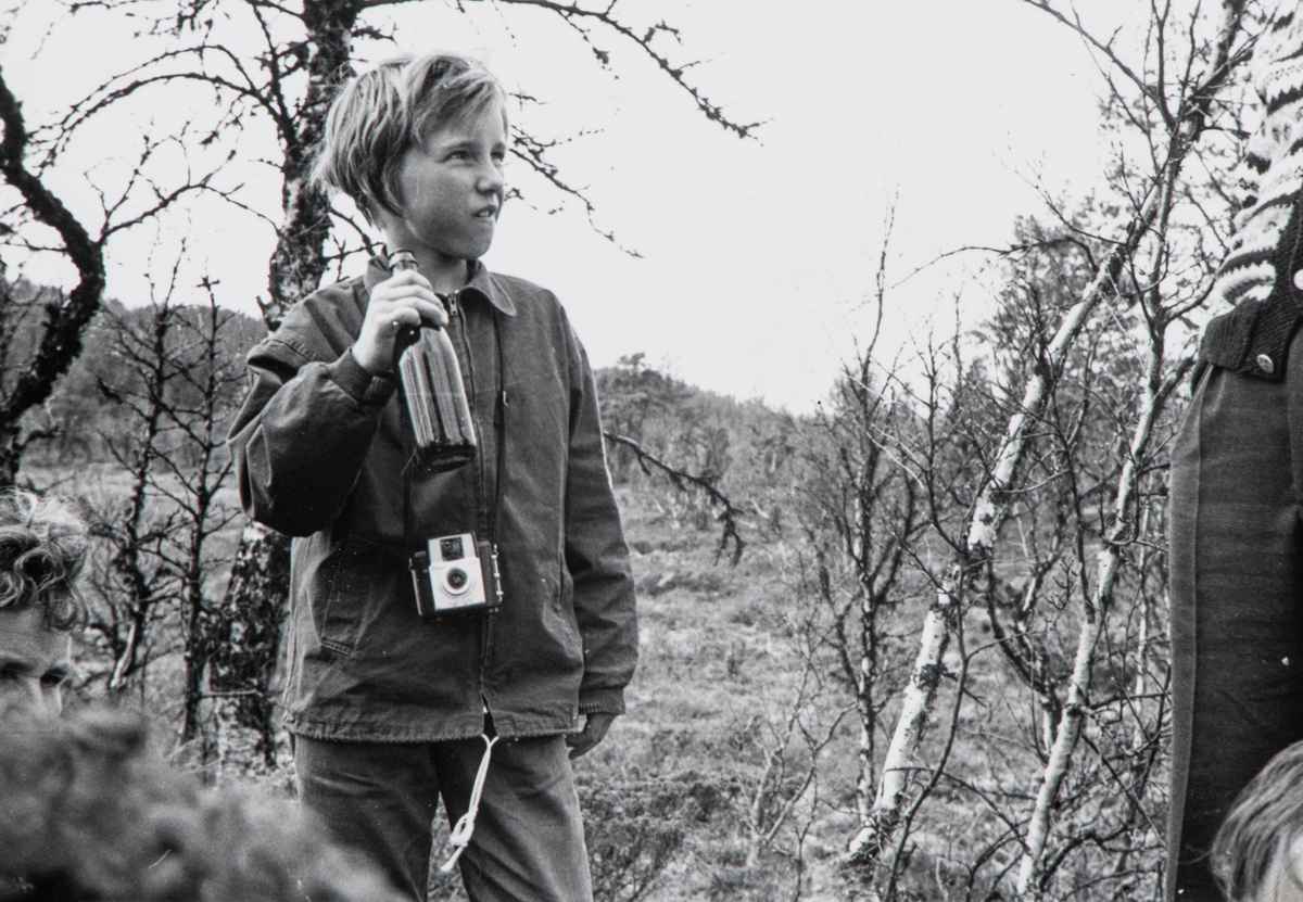 Wenche Furulund, født i 1950. På skogstur med fotoaparat på magen.