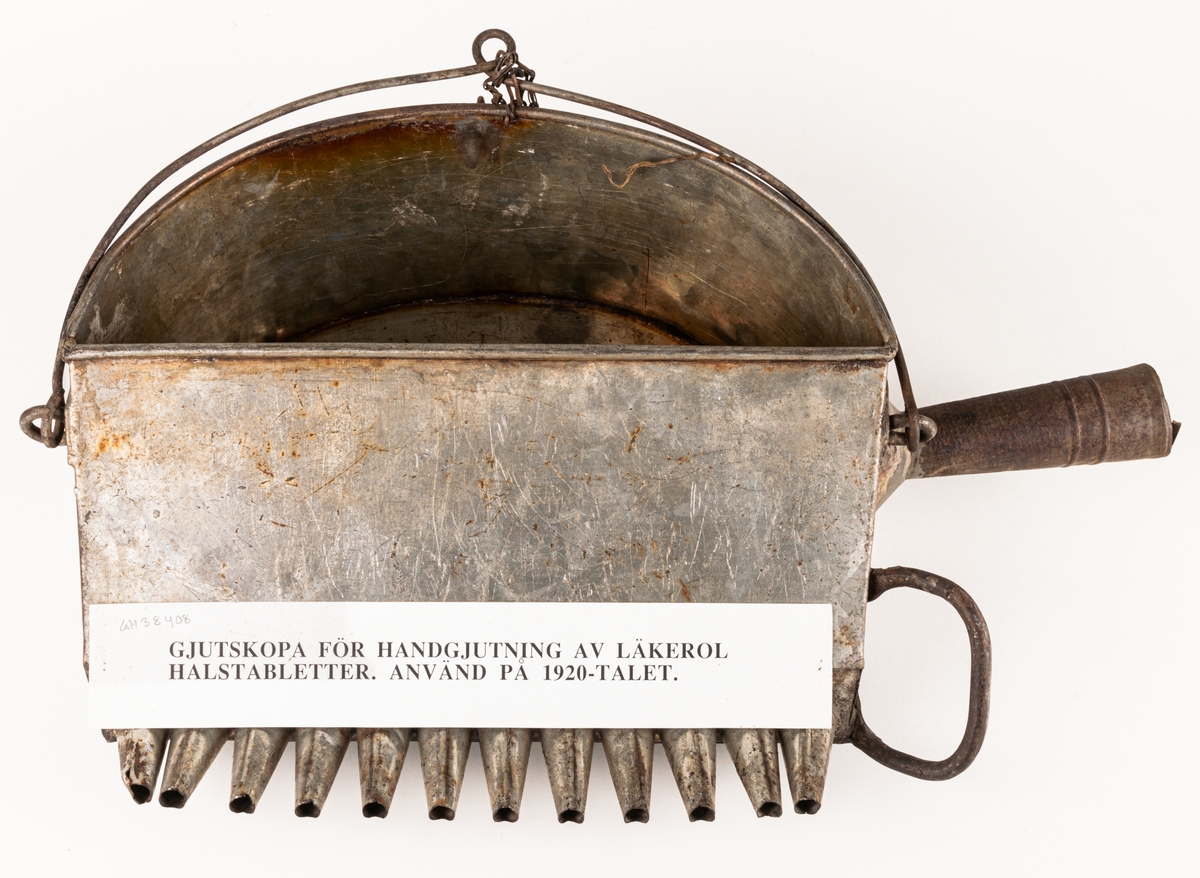 Gjutskopa, plåt, för handgjutning av Läkerol halstabletter, med 12 tapprör. Använd på 1920-talet.