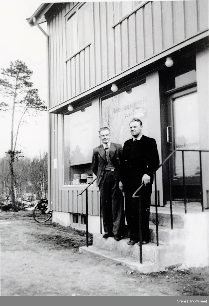 To menn står på trappen framfor "Kirkenes Koop Forening" på Svanvik. Harry Klippenvåg til høyre.