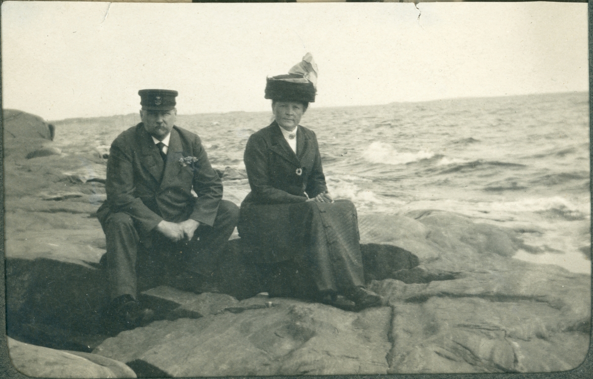 Kvinna och man som sitter på en klippa