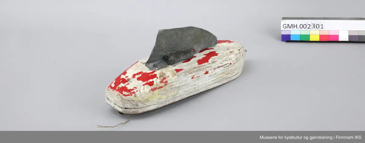 Båten har en massiv kropp med et påspikret dekk. En lasteluke er antydet med små deler av kryssfiner. Bak og foran finnes det en øyekrok til å feste en tau ved. på undersiden er det spikret på en metalldel og en kjøl av blikk. Baugen har rester etter rød og beige maling.