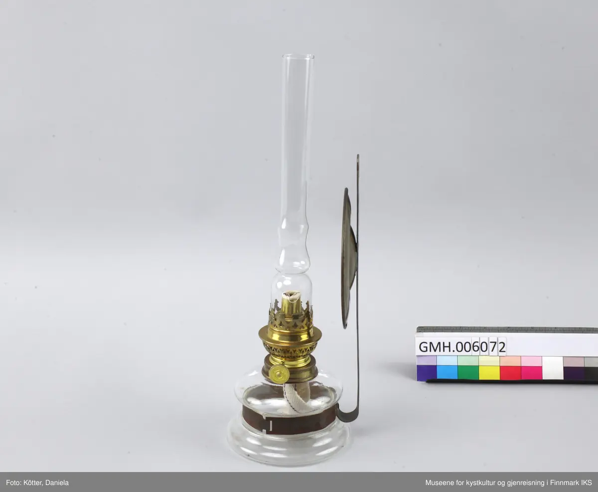 Lampen består av et glassbeholder som omfavnes av en metallspenne. Spenna er festet til en flat, vertikal metallstang som har et hull øverst for å henges på veggen. Ved metallstanga er det også festet en rund speil av messing som skal reflektere kampens lys. Øverst ved glassbeholderen skrues det fast en anordning med en mekanisme som tillater å justere veiens lengde samt at man setter på et glassrør for å beskytte flammen. 