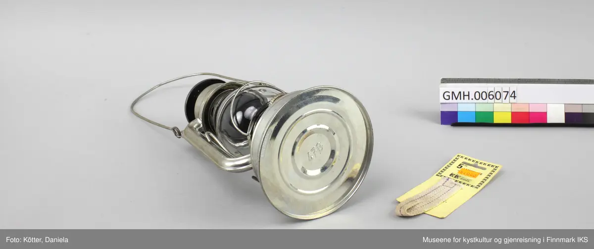 Lampen er laget av aluminium. Foten er brennstoffbeholderen. På den skrues det fast justermekanismen for veken. Lengden av veken justeres med en liten spak på siden. Glasset sitter i to bøyler og kan løftes ved å klaffe ned en liten spak. På hver side har lampa staver som går opp mot hetta med luftehull. Øverst er det en metalløkke til oppheng og lampa kan bæres ved en metallbøyle. Med lampen følger det en ny veke