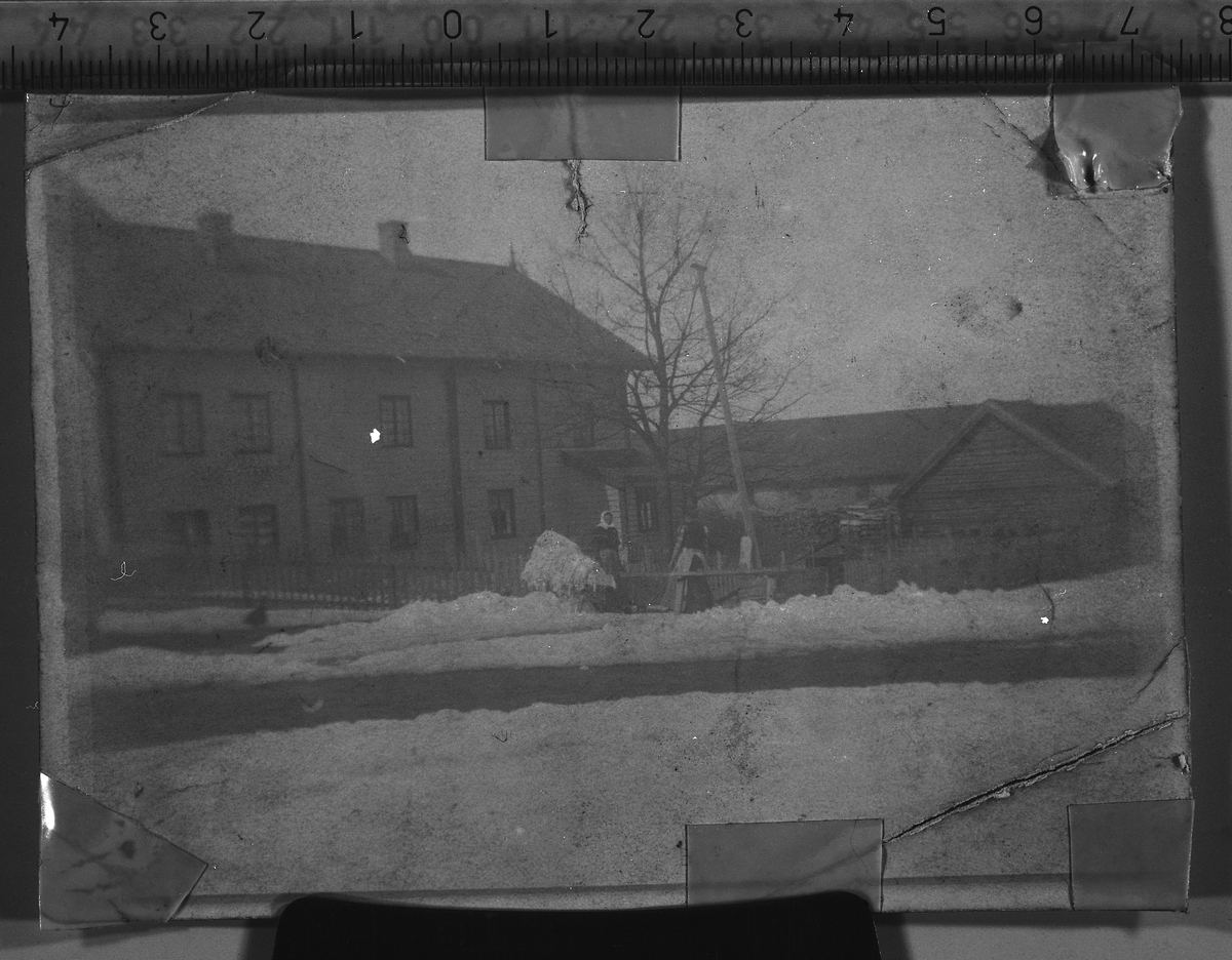 Klesvask på gårdsplassen på Hammerstad søndre i Totenvika på vårparten rundt 1908-10. Sju dentiske bilder, men med litt ulikt lys fra reprooperasjonen. Helene Hermanrud (f.1862) og Marie Håkonsen fra Feiring står ute på gårdsplassen ved vannposten og skyller klærne. Vasken hade foregått inne i størhuset. Helene og Marie hjalp Mina Årsby med klesvasken gjerne 3-4 ganger i året, til jul, til  påske, og gjerne et par ganger på sommeren. Når det var is på Mjøsa skyllet de gjerne klærne i mjøsa.