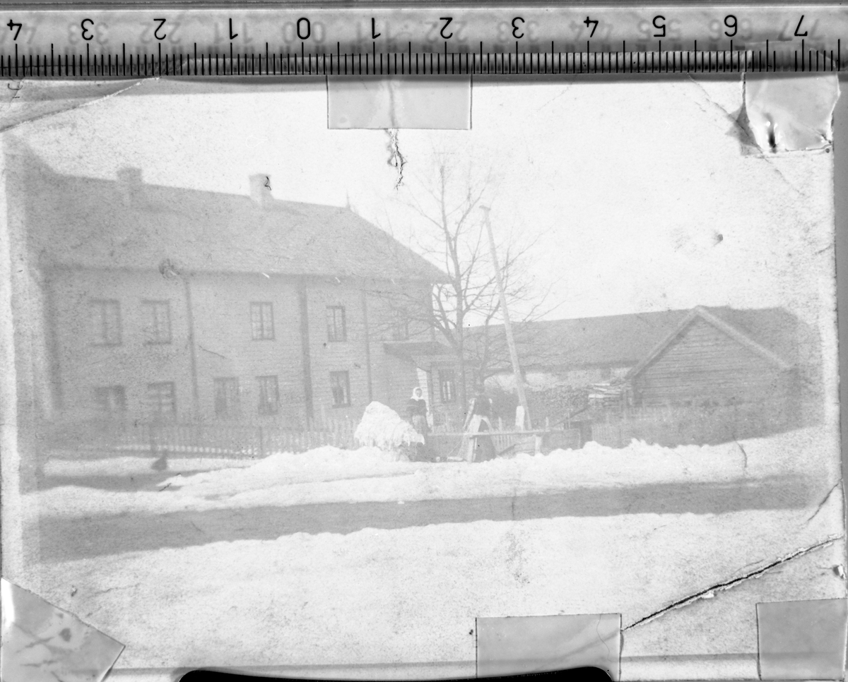 Klesvask på gårdsplassen på Hammerstad søndre i Totenvika på vårparten rundt 1908-10. Sju dentiske bilder, men med litt ulikt lys fra reprooperasjonen. Helene Hermanrud (f.1862) og Marie Håkonsen fra Feiring står ute på gårdsplassen ved vannposten og skyller klærne. Vasken hade foregått inne i størhuset. Helene og Marie hjalp Mina Årsby med klesvasken gjerne 3-4 ganger i året, til jul, til  påske, og gjerne et par ganger på sommeren. Når det var is på Mjøsa skyllet de gjerne klærne i mjøsa.