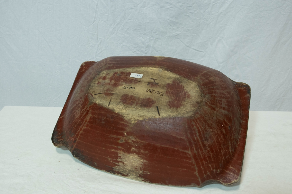 Rektangulær brun tretraug med avrundede kanter. Gjenstanden har utskjært dekorativ bord