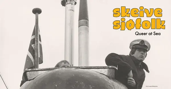 Sort hvitt foto av en sjømann som står til høyre i bildet. Han står på et skip. Til venstre ser vi det norske flagget